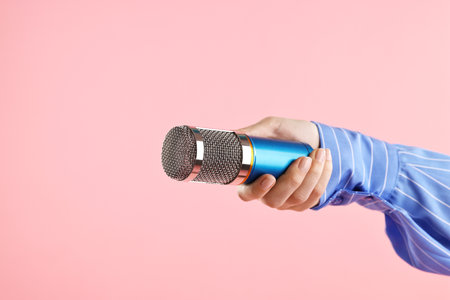 Woman with microphone on pink background, closeupの写真素材