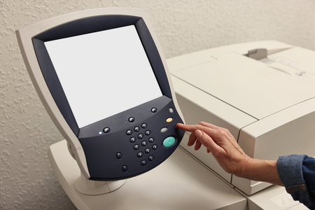 Woman using modern printer indoors, closeup. Printing house