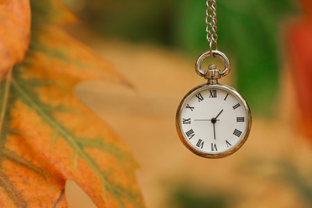 Autumn time. Chain watch on blurred background, closeup with space for textの写真素材