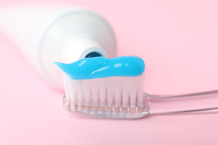 Toothbrush with toothpaste and tube on pink background, closeupの写真素材