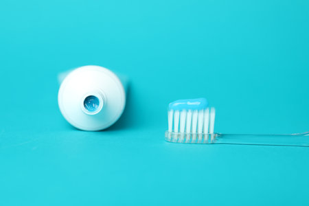 Toothbrush with toothpaste and tube on light blue backgroundの写真素材