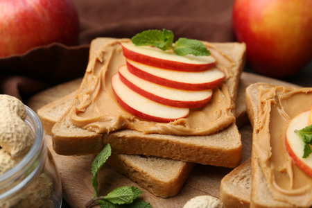 Tasty sandwiches with peanut butter, apples and mint on table, closeupの写真素材
