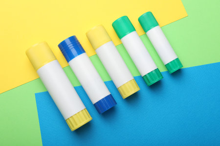 Sticks of glue on color background, flat layの写真素材
