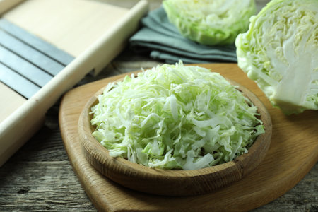 Fresh shredded cabbage and shredder on wooden table, closeupの写真素材