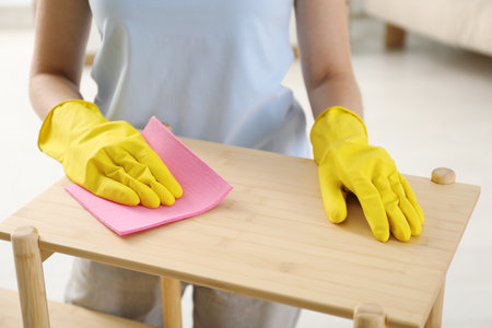 Young woman cleaning wooden shelf with rag at home, closeupの写真素材