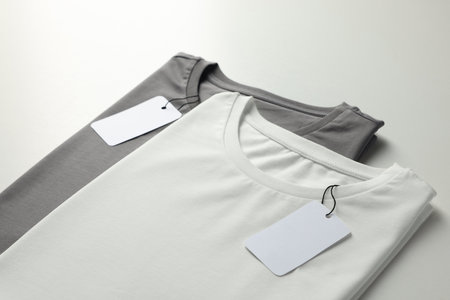 Different blank t-shirts on white background, closeup. Mockup for design