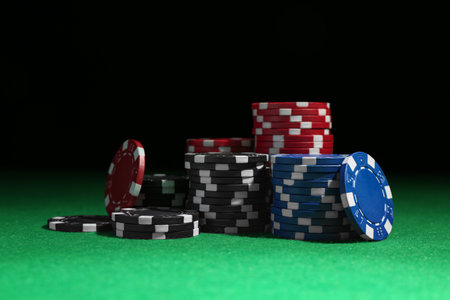 Poker chips on green table against dark backgroundの写真素材