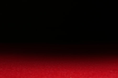 Red textured surface against dark background, selective focus