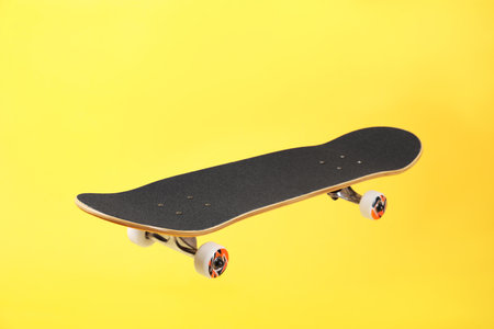 One skateboard on yellow background. Sports equipmentの写真素材