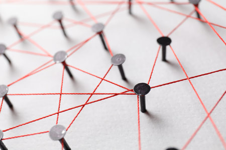 Network connection. Nails linked together by thread on white table, closeupの写真素材