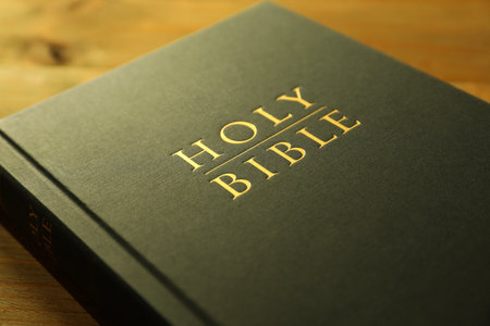 Hardcover Holy Bible on wooden table, closeupの写真素材