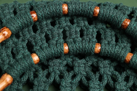 Macrame shopping bag with wooden handles as background, closeup