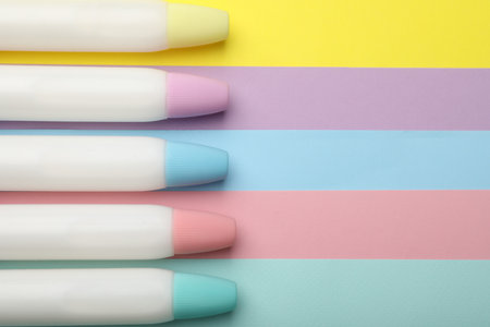 Sticks of glue on color background, flat lay. Space for textの写真素材