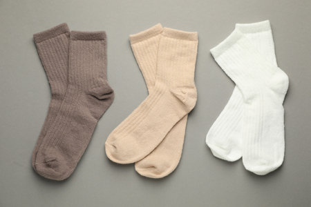 Different soft socks on light gray background, flat lay