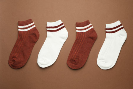 Different soft socks on light brown background, flat layの写真素材