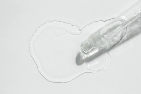 Cosmetic oil and pipette on light gray background, top viewの写真素材