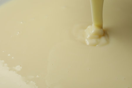 Pouring delicious condensed milk as background, closeupの写真素材