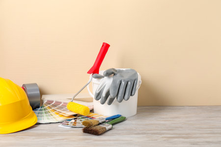 Different painter's tools on light wooden table, space for text. Decorating and design