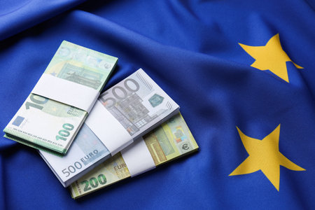 Euro banknotes on European Union flag, above viewの写真素材