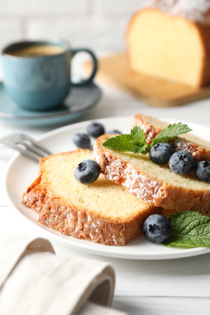 Freshly baked sponge cake, mint and blueberries on white wooden table, closeupの写真素材