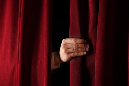 Man closing red front curtains in theater, closeupの写真素材