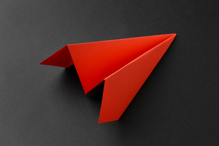 One handmade orange paper plane on gray background, closeupの写真素材