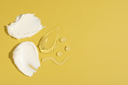 Samples of different cosmetic products on yellow background, flat lay. Space for textの写真素材