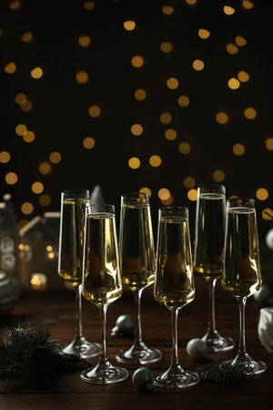 Champagne in glasses and decor on wooden table against blurred Christmas lights. Bokeh effectの写真素材