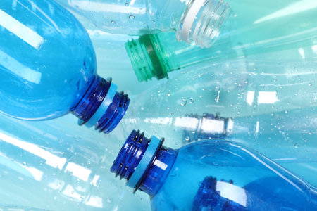Many plastic bottles on light background, closeup