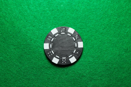 Poker chip on green table, top view