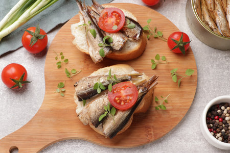Delicious sandwiches with sprats served in gray table, top viewの写真素材