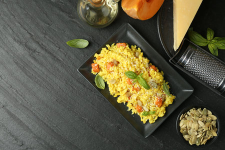 Delicious pumpkin risotto served on black table, flat lay. Space for textの写真素材