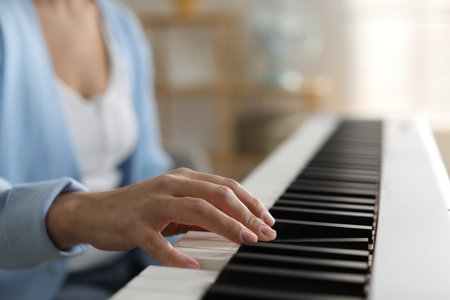 Woman playing synthesizer indoors, closeup. electronic musical instrumentの写真素材
