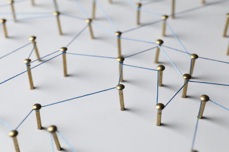Network connection. Nails linked together by thread on white table, closeupの写真素材