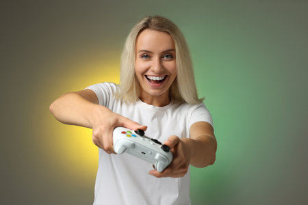 Person playing video games with controller on color background