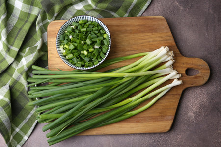 Chopped green onion and stems on brown table, top viewの写真素材