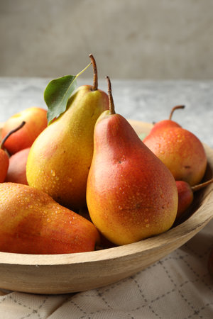 Ripe juicy pears in bowl on table, closeupの写真素材