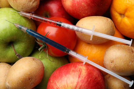 GMO concept. Different products and syringes as background, top viewの写真素材