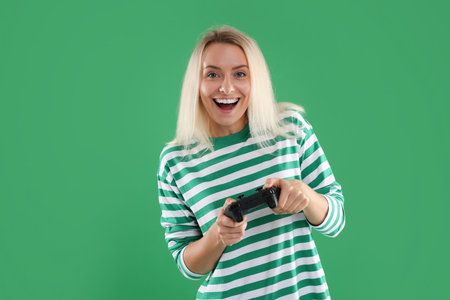 Person playing video games with controller on green background