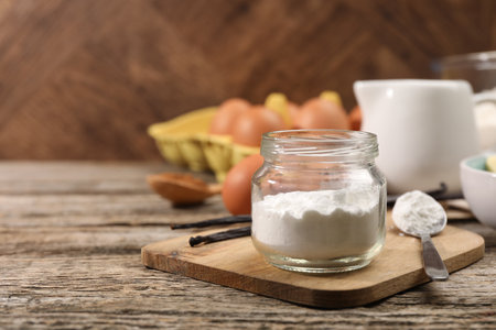 Baking powder in jar on wooden table, closeup. Space for textの写真素材
