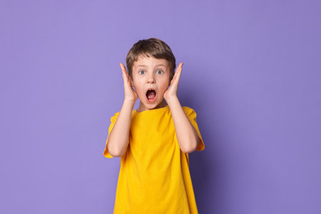 Portrait of little boy on violet background