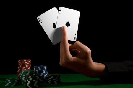Woman with playing cards and poker chips at green table, closeup