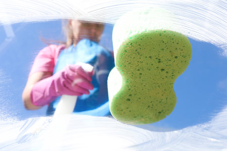Cleaning window with sponge against blue sky, closeupの写真素材