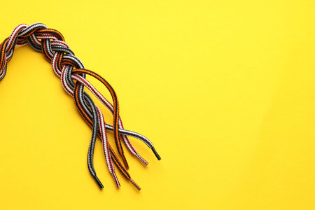 Braided colorful ropes on yellow background, top view with space for text. Unity conceptの写真素材