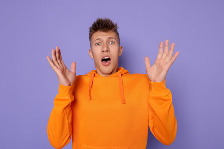 Portrait of young man on violet background
