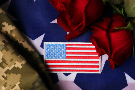 Veterans day. USA army patch, rose flowers and military uniform on American flag, flat layの写真素材