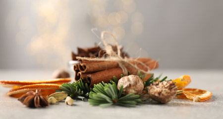 Different spices, dried orange slices and fir tree branches on light gray table, closeup. Christmas seasonの写真素材