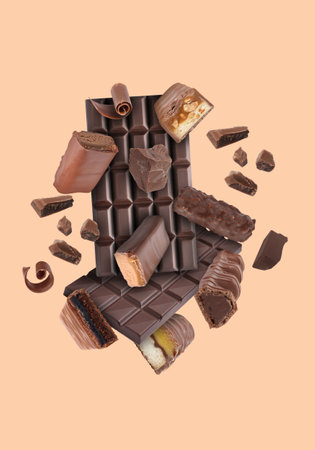 Different chocolate products in air on pink beige backgroundの写真素材