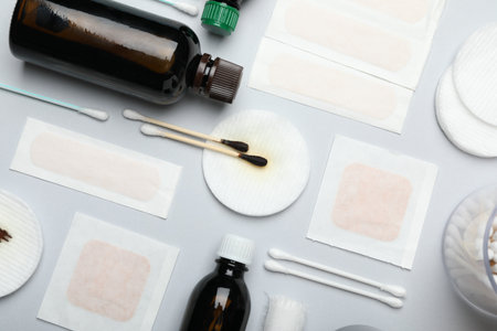Topical iodine and other first aid kit components on light gray background, flat layの写真素材