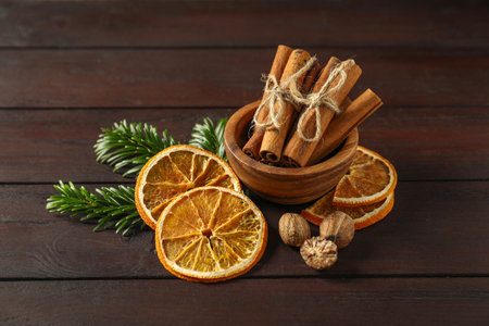 Different spices, dried orange slices and fir tree branches on wooden table.の写真素材